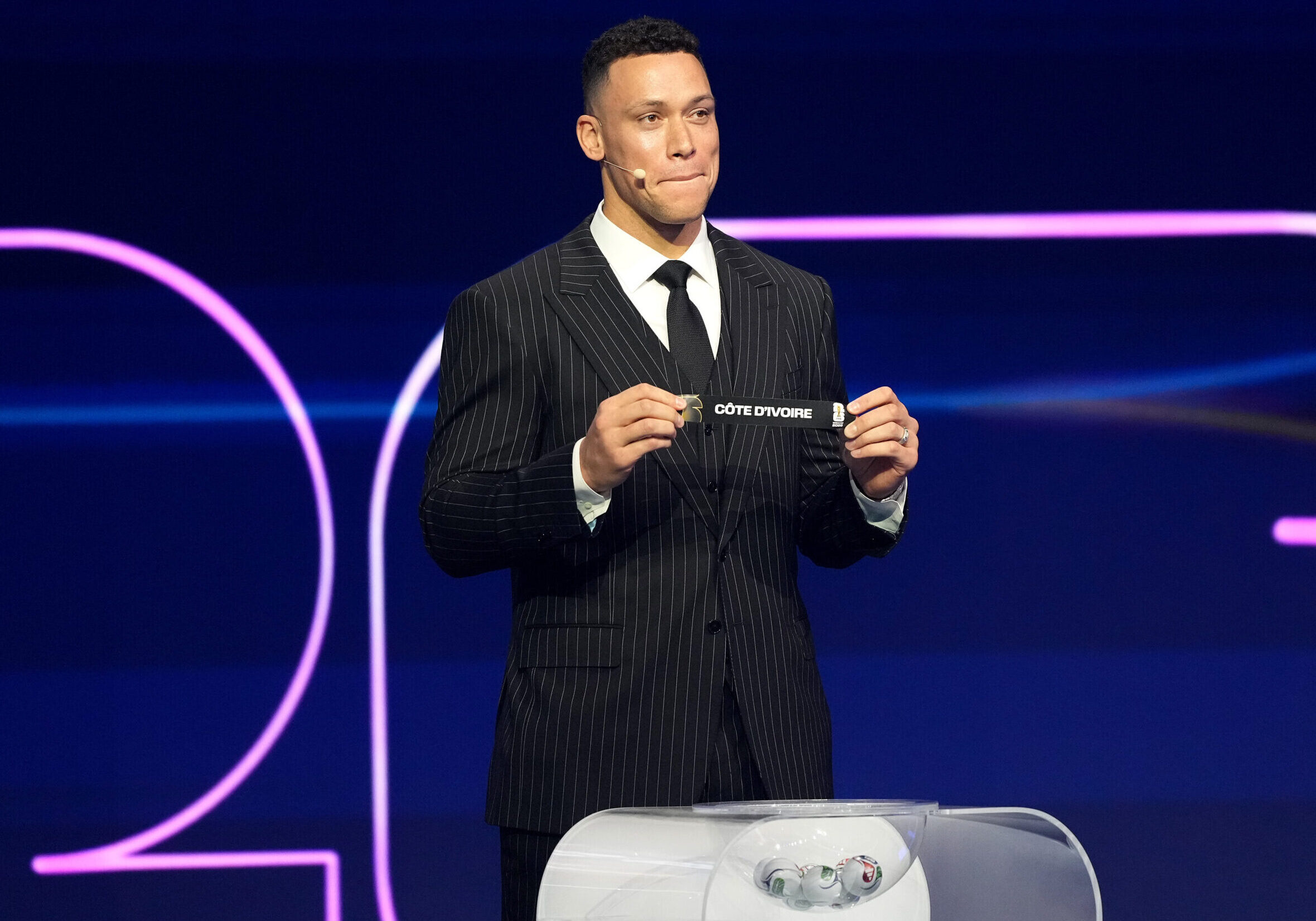 WASHINGTON, DC - DECEMBER 05: Draw assistant Aaron Judge  draws out the card of Ivory Coast during the FIFA World Cup 2026 Official Draw at John F. Kennedy Center for the Performing Arts on December 05, 2025 in Washington, DC. (Photo by Stephanie Scarbrough - Pool/Getty Images)